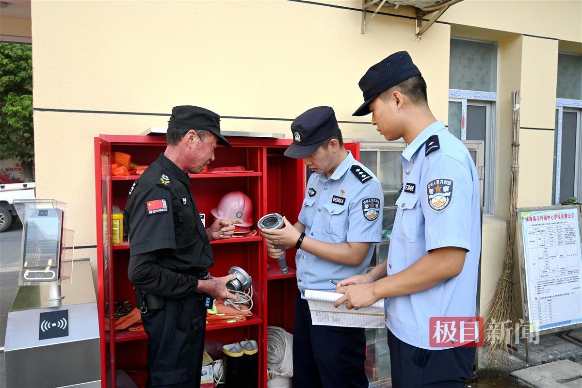 图3：寺坪派出所民警在检查校园消防设备.JPG