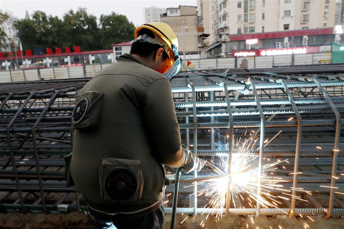 地铁工地焊工穿着风扇服焊接钢筋笼，有效保障了劳动者身体健康和项目建设安全。袁永华 摄.JPG