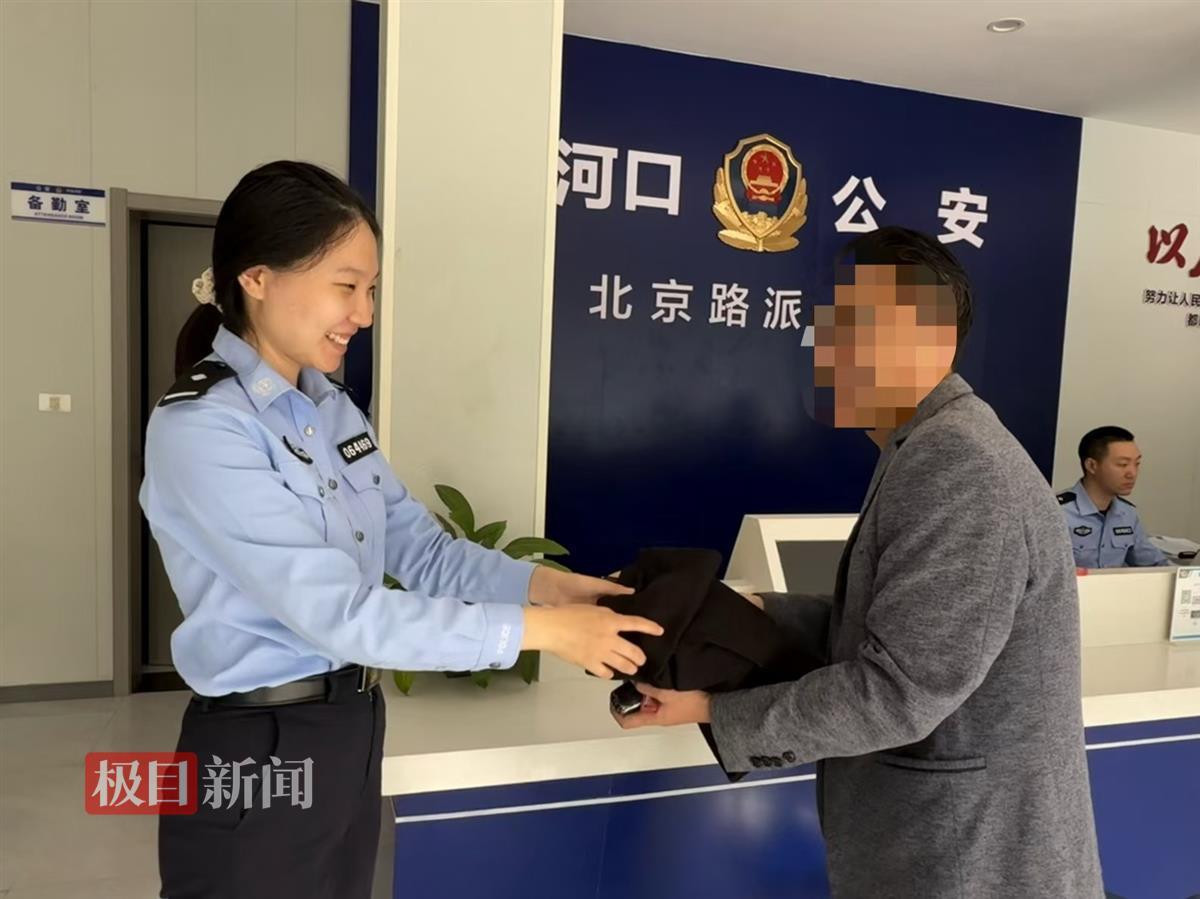 图为民警将醉酒男子遗落物品返还.jpg