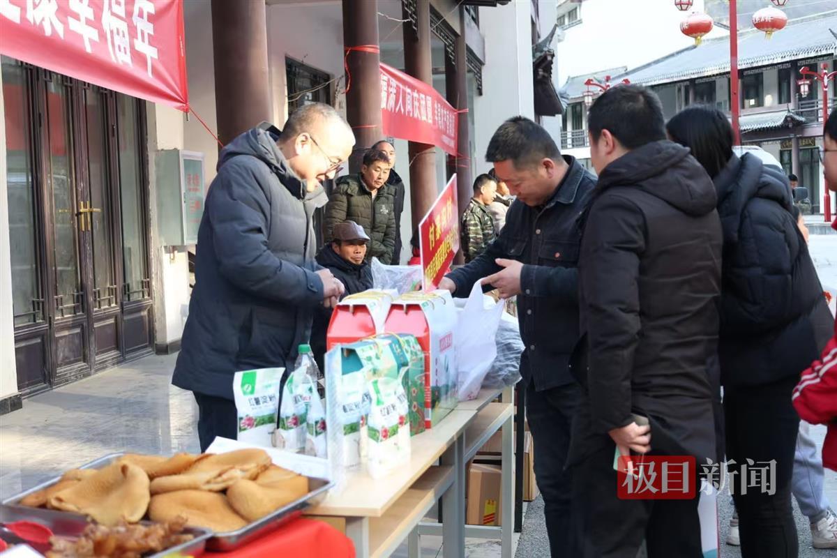 图为非遗美食、农特产品展位前围满了购买年货的群众。 邹景根摄.jpg
