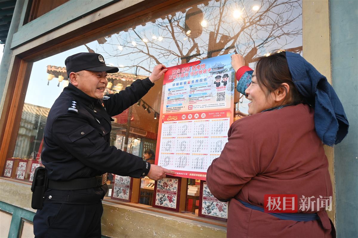 民警和群众一起张贴“反诈日历”.JPG