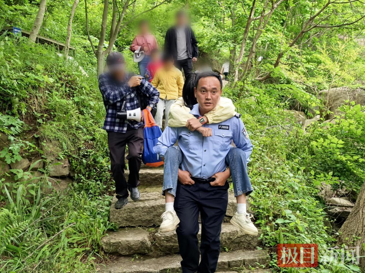 大悟县公安局民警辅警将脚踝受伤的女孩转移至安全区域，交由医护人员救治。.jpg