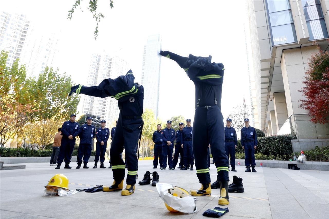 11月29日，武汉地铁迅和公司物业服务技能竞赛消防实战项目，选手正在快速穿戴灭火防护服，以应对模拟的复杂火情。袁永华 摄.jpg