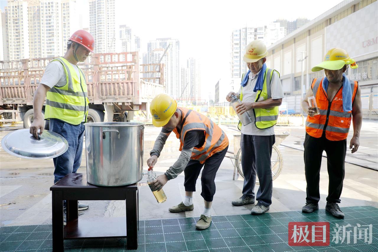 武汉地铁12号线太平洋站项目建设现场，工人正喝酸梅汤解暑。张敏 摄.jpg