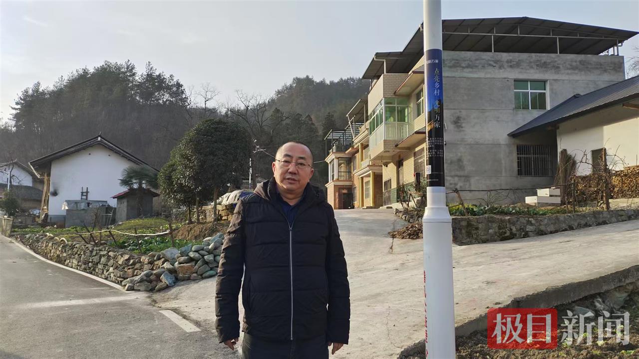 图为北京感恩公益基金会理事长周健与建好的路灯合影。 徐光意摄.png