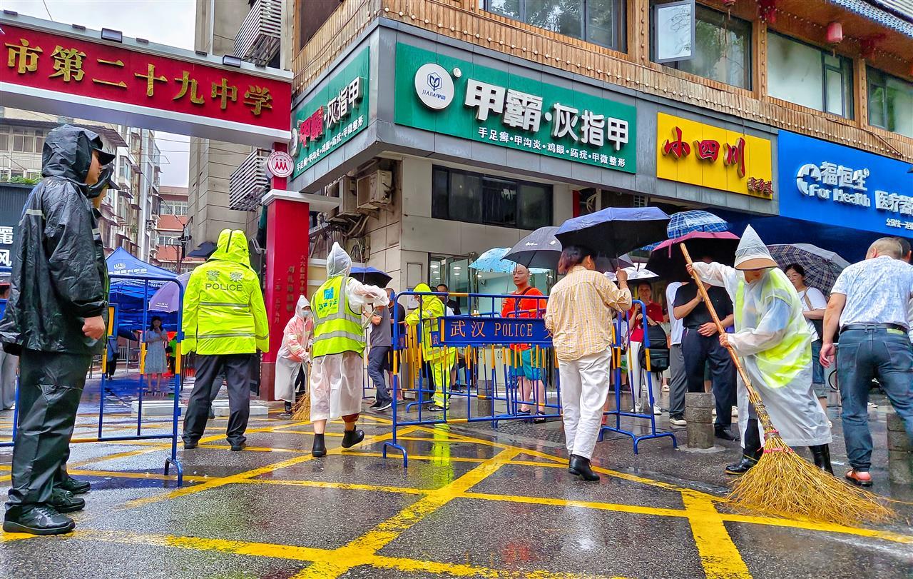 图7：环卫工人清理利济北路市第二十九中考点外的地面渍水.jpg