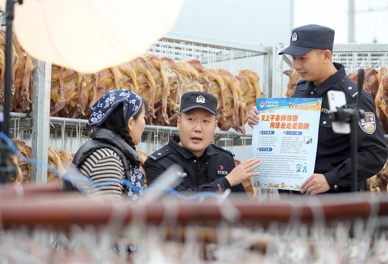 民警在辖区腊货食品加工企业，向员工宣传反诈知识.jpg