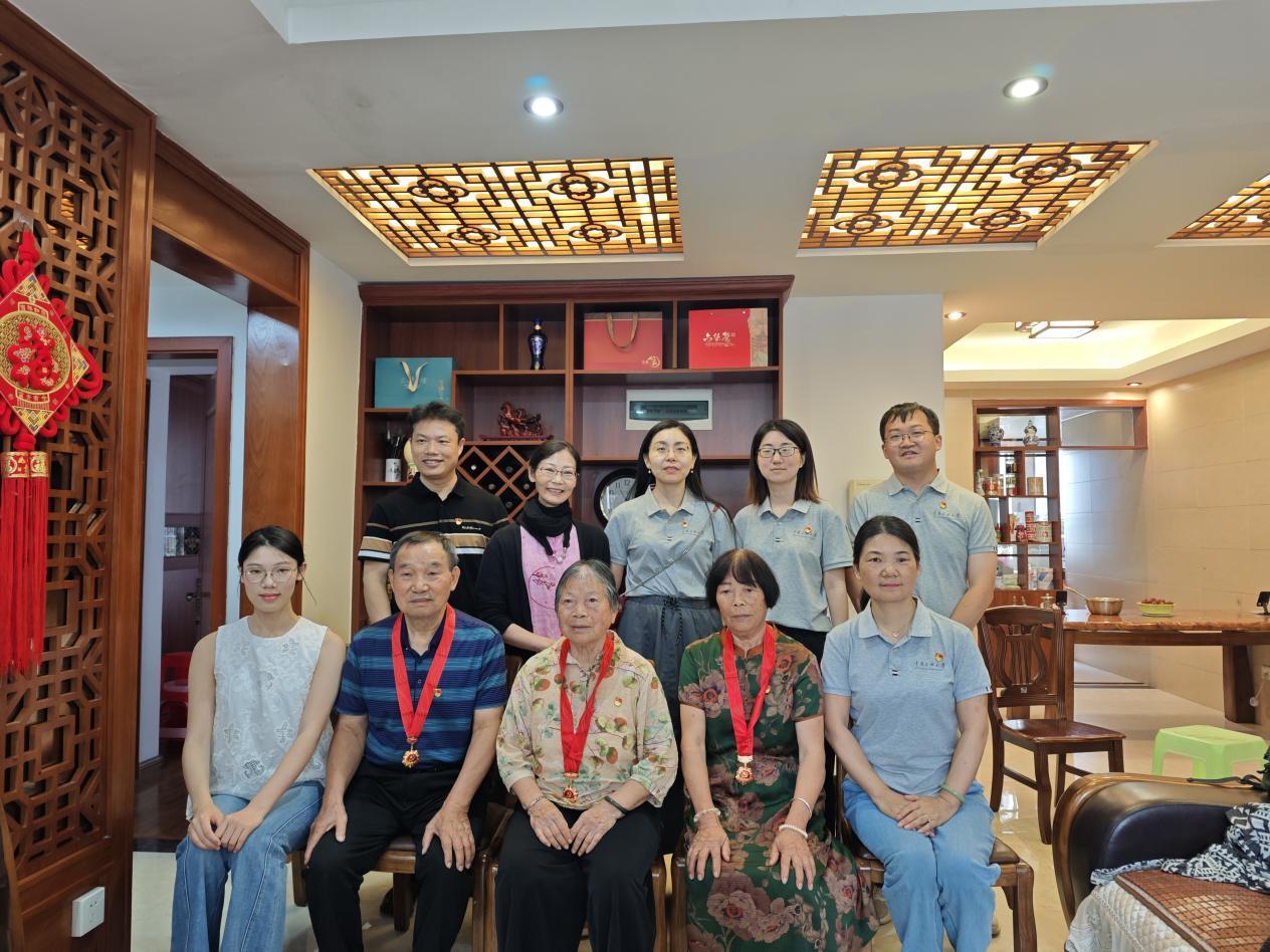 广西家访队伍与三位党龄逾50年的党员合影。学校供图.png