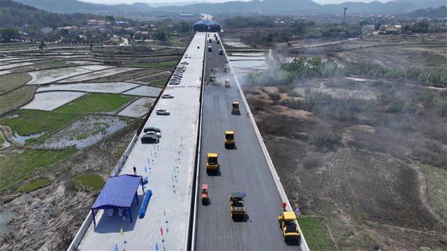 武汉至重庆高速公路路面摊铺沥青，预计2025年通车
