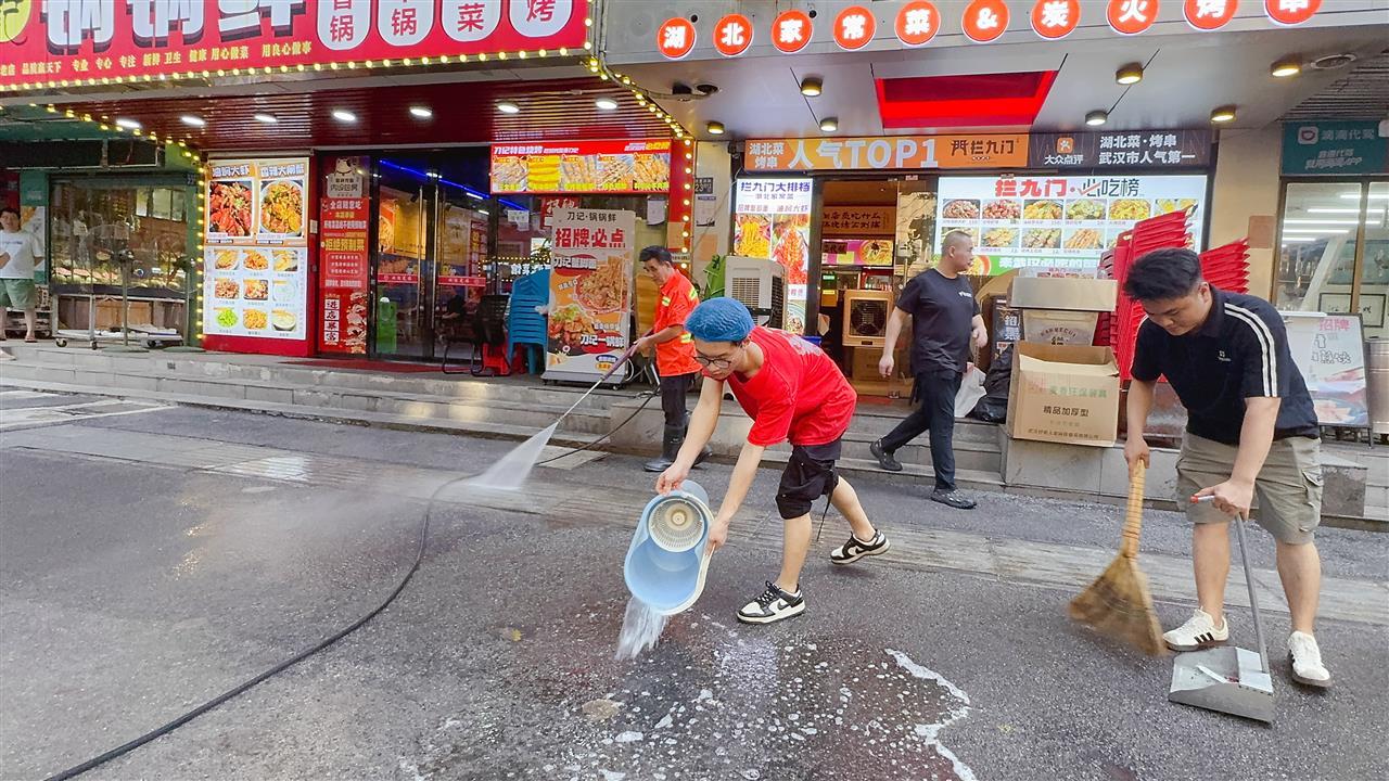 图6：拦九门火锅烧烤店店主张晓明（右1）与员工一起“自清门前洁”.jpg