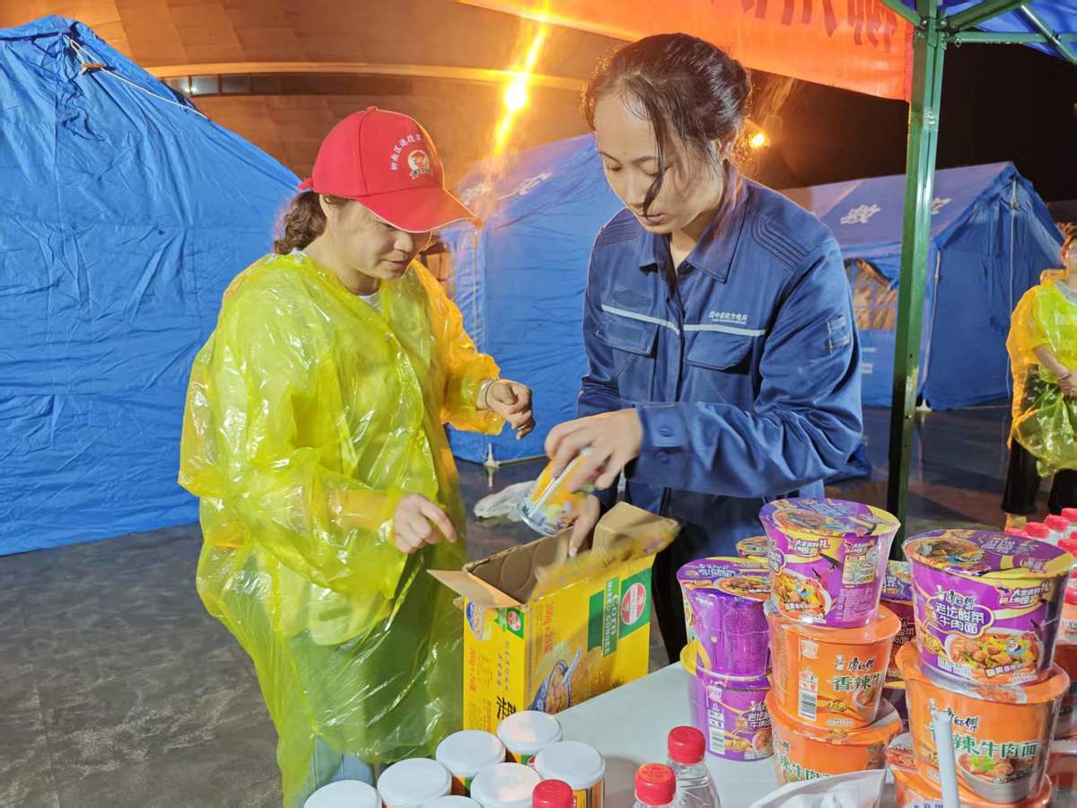 5月18日，南方电网广西柳州供电局在柳州市柳南区太阳村镇螺蛳粉小镇安置区设立爱心服务站，为受灾安置群众送上饮用水、方便面等急需物资。（钟帆 摄）.jpg
