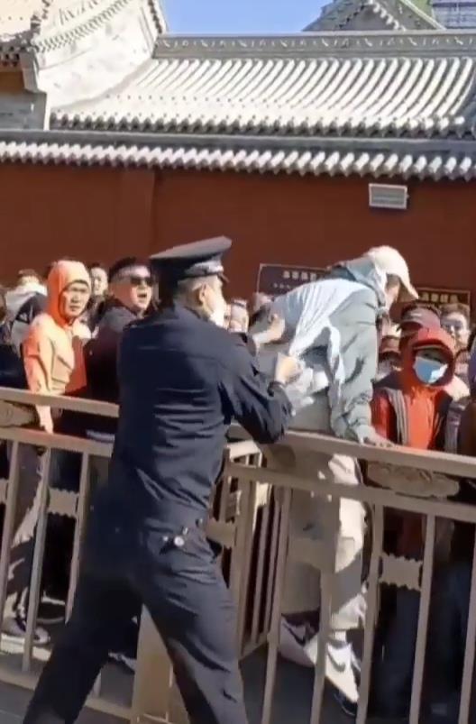 男子五台山翻栏杆插队，警察一把将其“薅”出