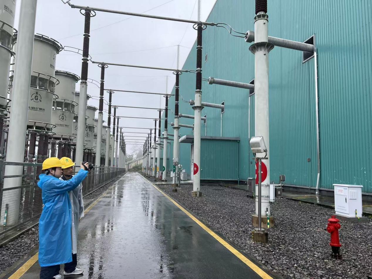 施州换流站运维人员高杰和陈照源对穿墙套管进行暴雨特巡。石镇宇摄.png
