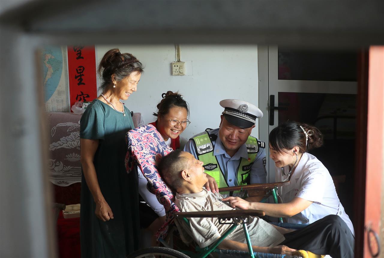 十里铺派出所民警带着医护人员上门为行动不便的村民义诊。.jpg