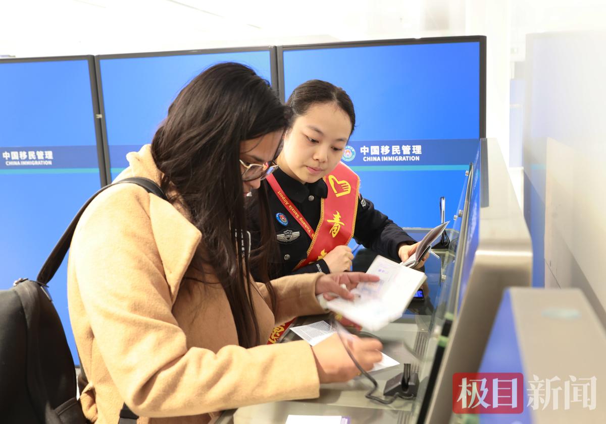 图为民警协助旅客办理手续 （钟鹏宇摄）.JPG