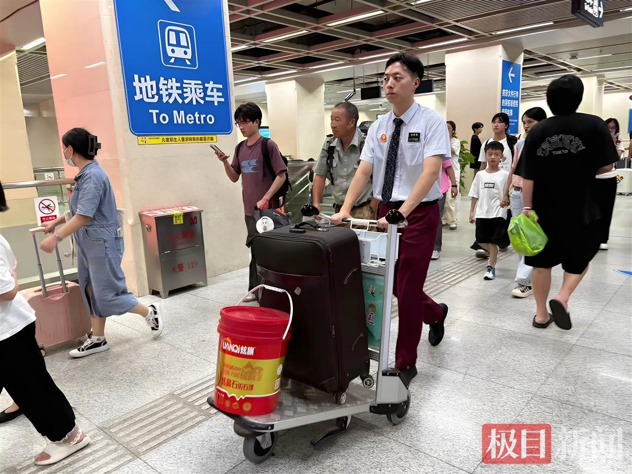 双节假期，武汉地铁汉口车站值班员用推车帮乘客转运行李。王晓娟 摄.jpg