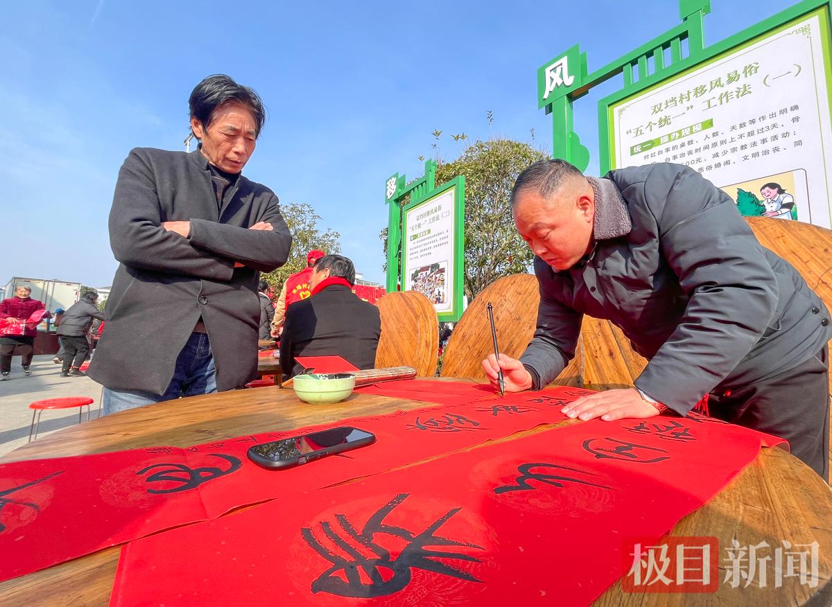 2月8日，荆州区马山镇双垱村团年宴现场，荆州本土资深的楚竹书文字研究者黄有志用蝌蚪文写春联。（极目新闻记者 黄志刚 摄）.jpg