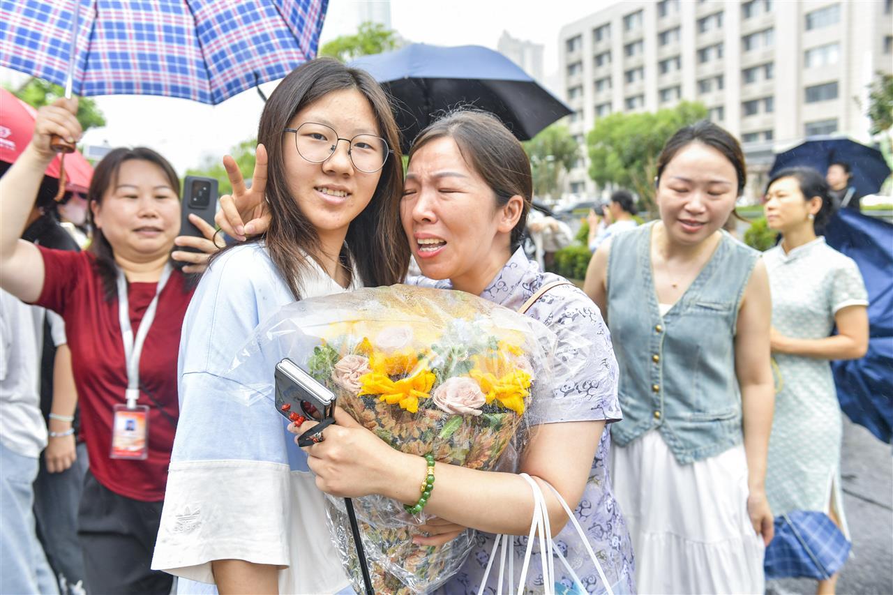 高考第三天，地理考试结束，手举鲜花、噙满热泪地拥抱高完试的女儿1.jpg