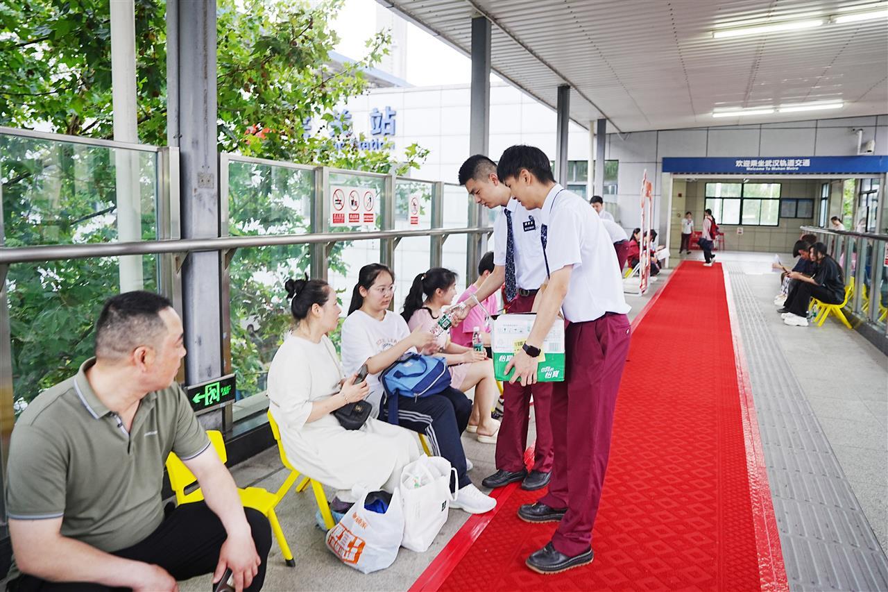 早上7时许，地铁1号线司机志愿者向提前到站的考生和家长送上矿泉水 产启斗摄.JPG
