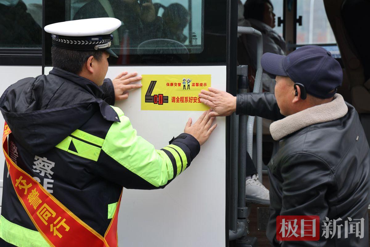 图3：交警在客车上张贴安全警示标语.JPG
