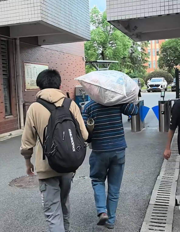 父亲扛着行李接儿子回家.jpg