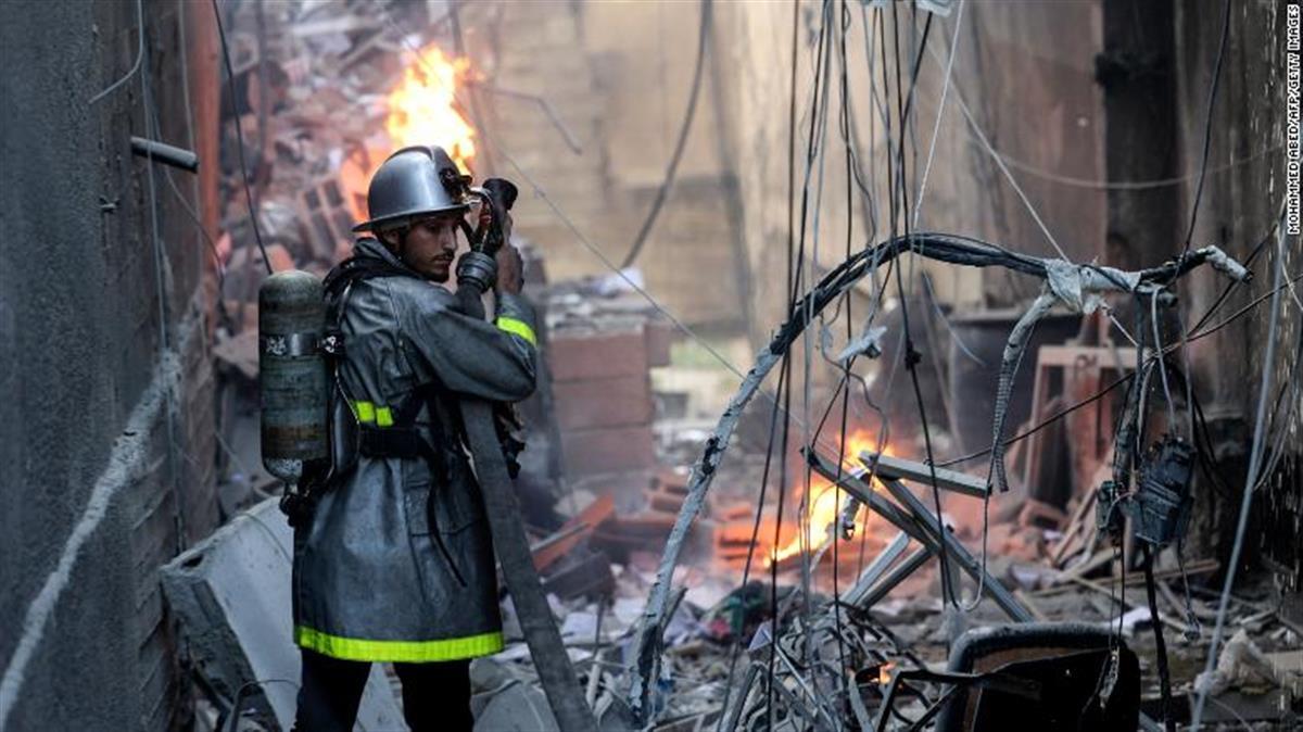 5日,以色列空袭加沙城后,一名巴勒斯坦消防员在灭火 (图源:cnn)