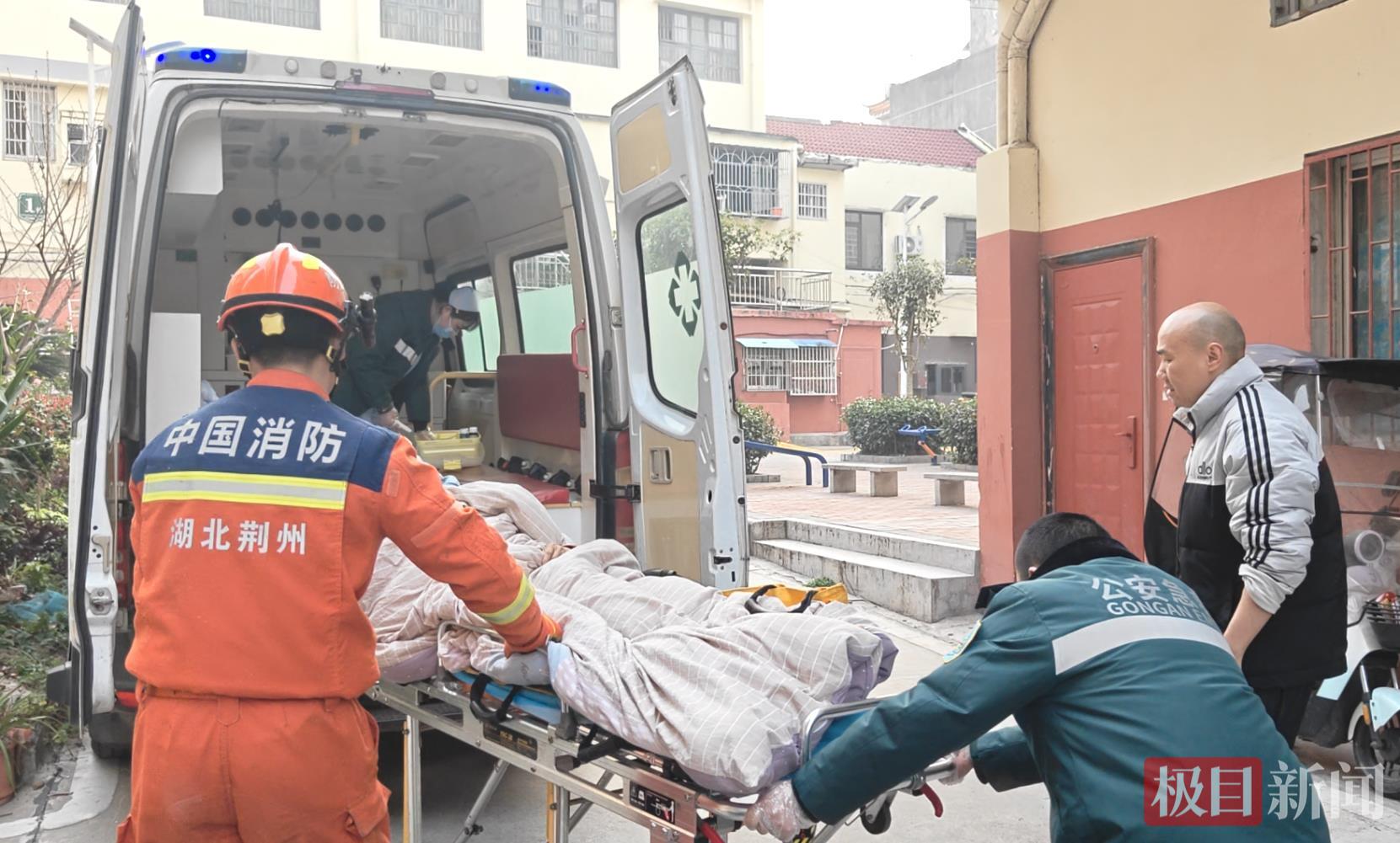 消防救援人员协助医护人员帮助转运女子 （视频截图）.png