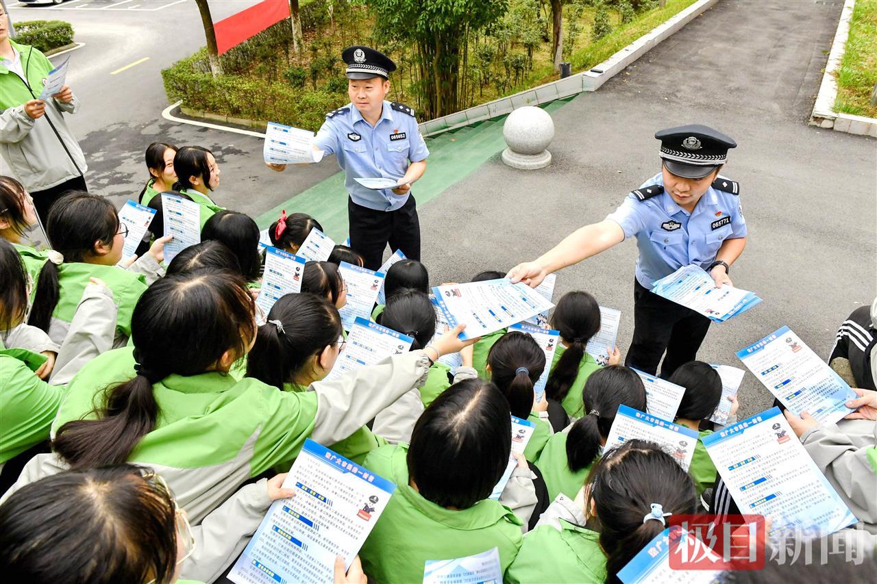 图4：民警向毕业生发放防电信诈骗资料.jpg