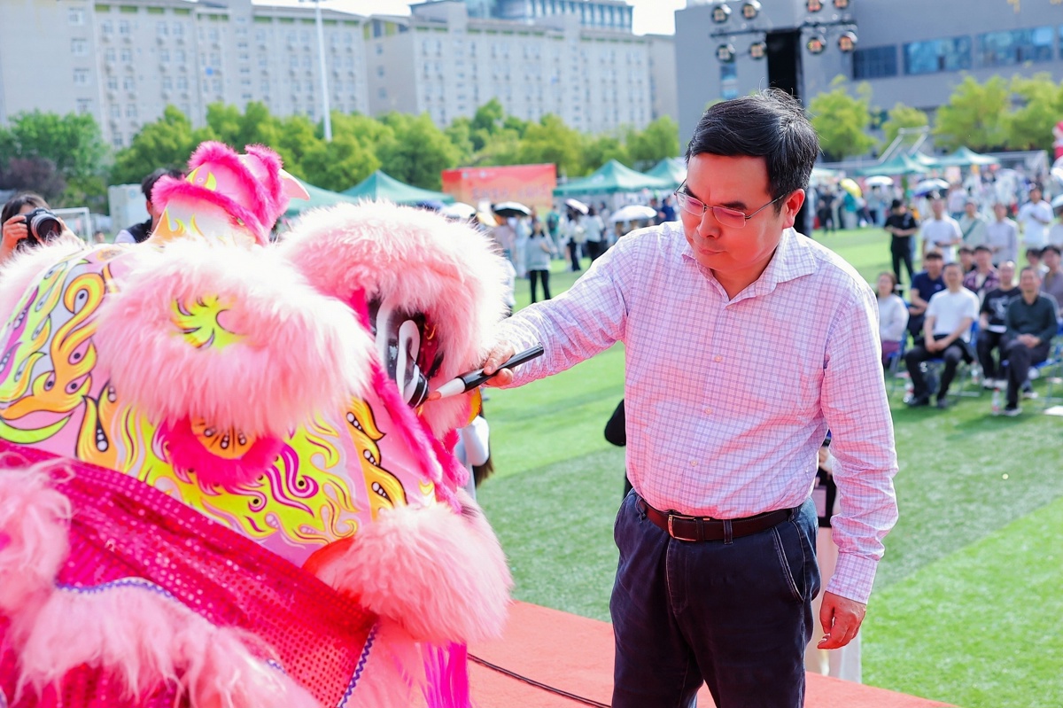 中南民族大学党委书记徐业勤为瑞狮点睛。学校供图.jpg