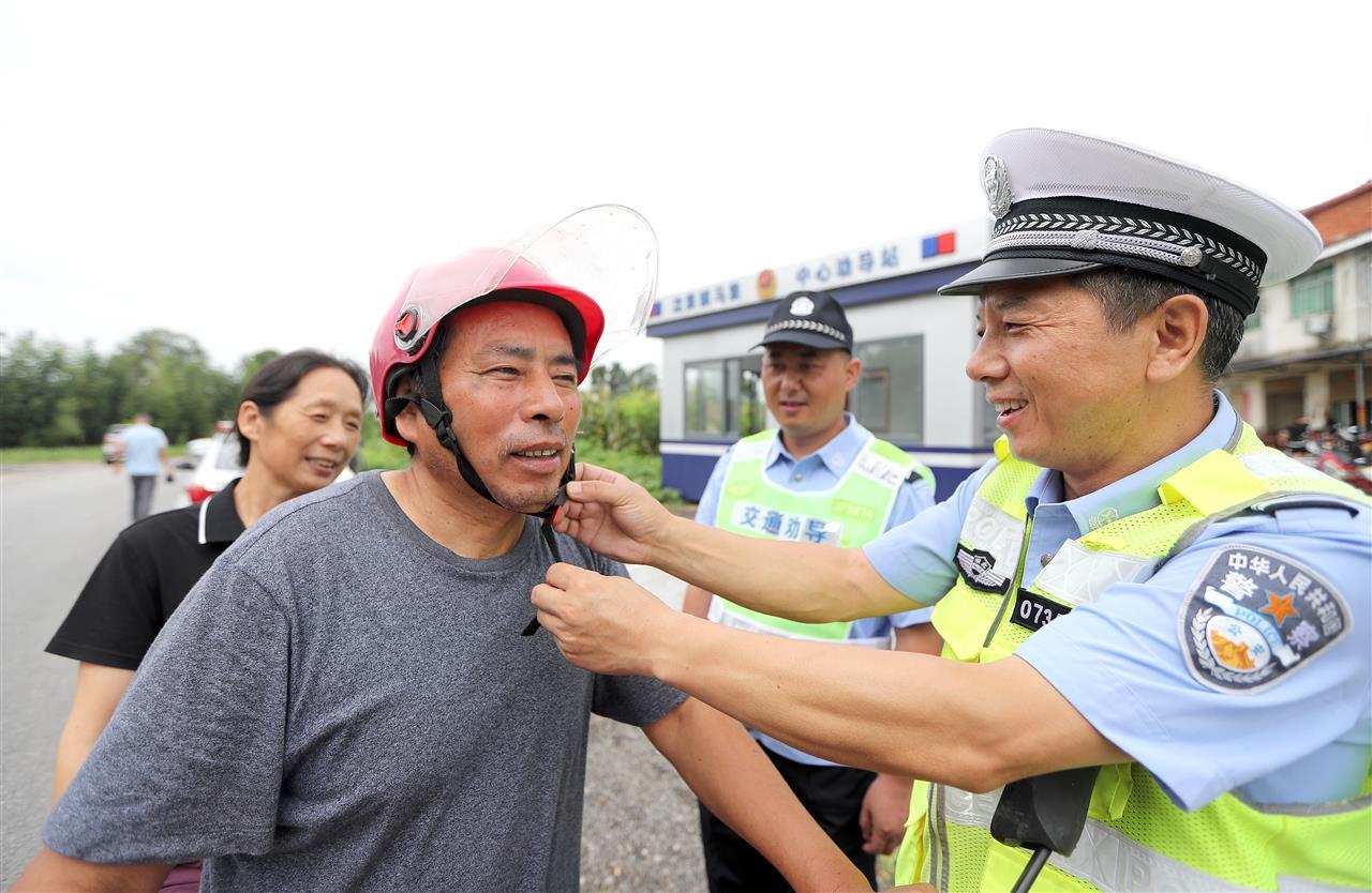 民警向过往群众普及安全头盔的正确佩戴方式.jpg