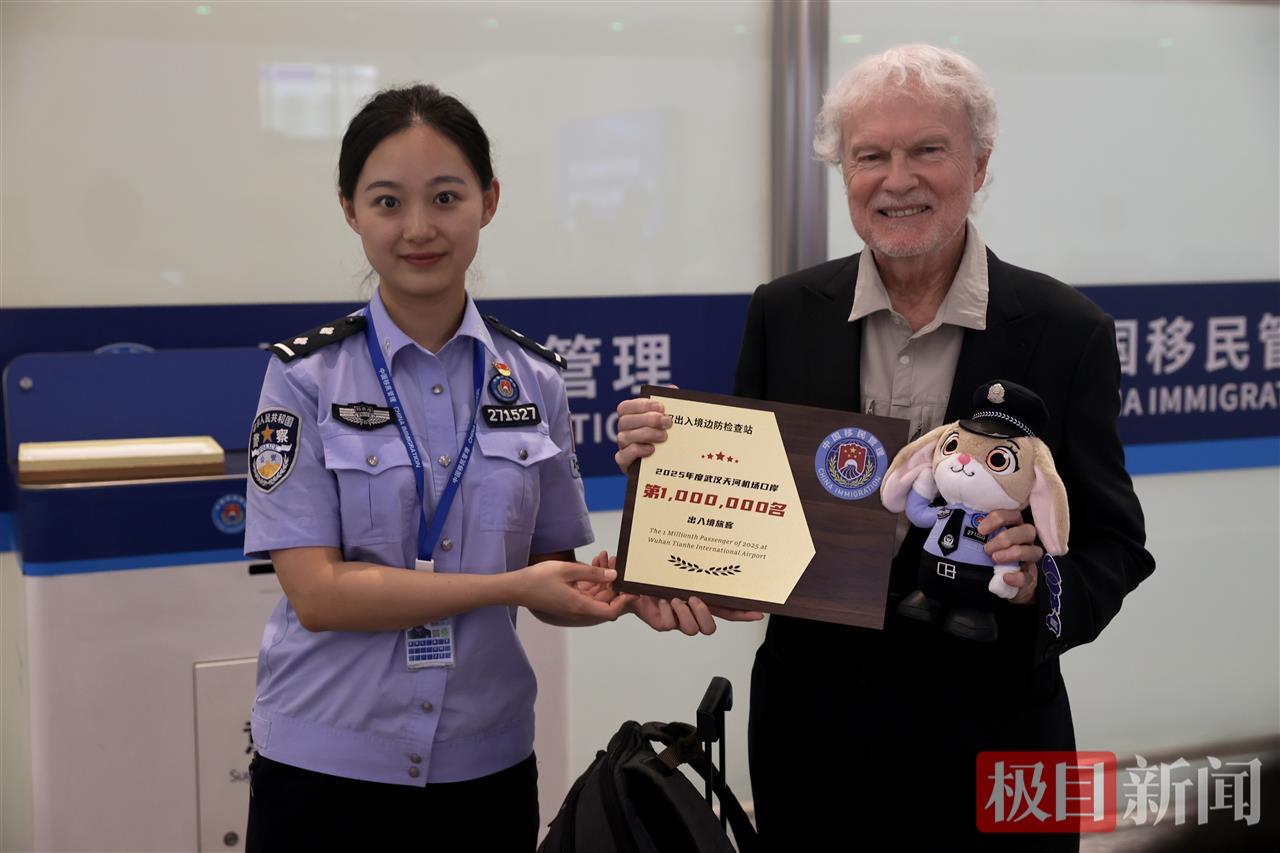 武汉边检站民警为第100万名旅客送上纪念品.jpg