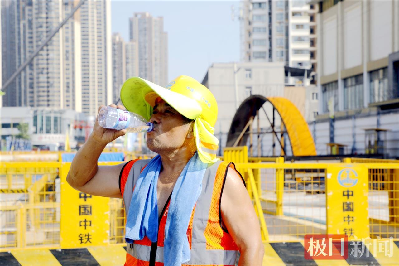 武汉地铁12号线太平洋站项目建设现场，负责文明施工的周师傅喝纯净水解暑。张敏 摄.jpg
