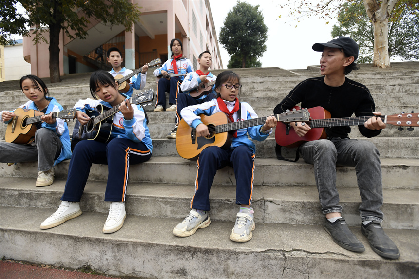 樟树市昌傅镇中心小学的学生在音乐老师的指导下学弹吉他周亮摄