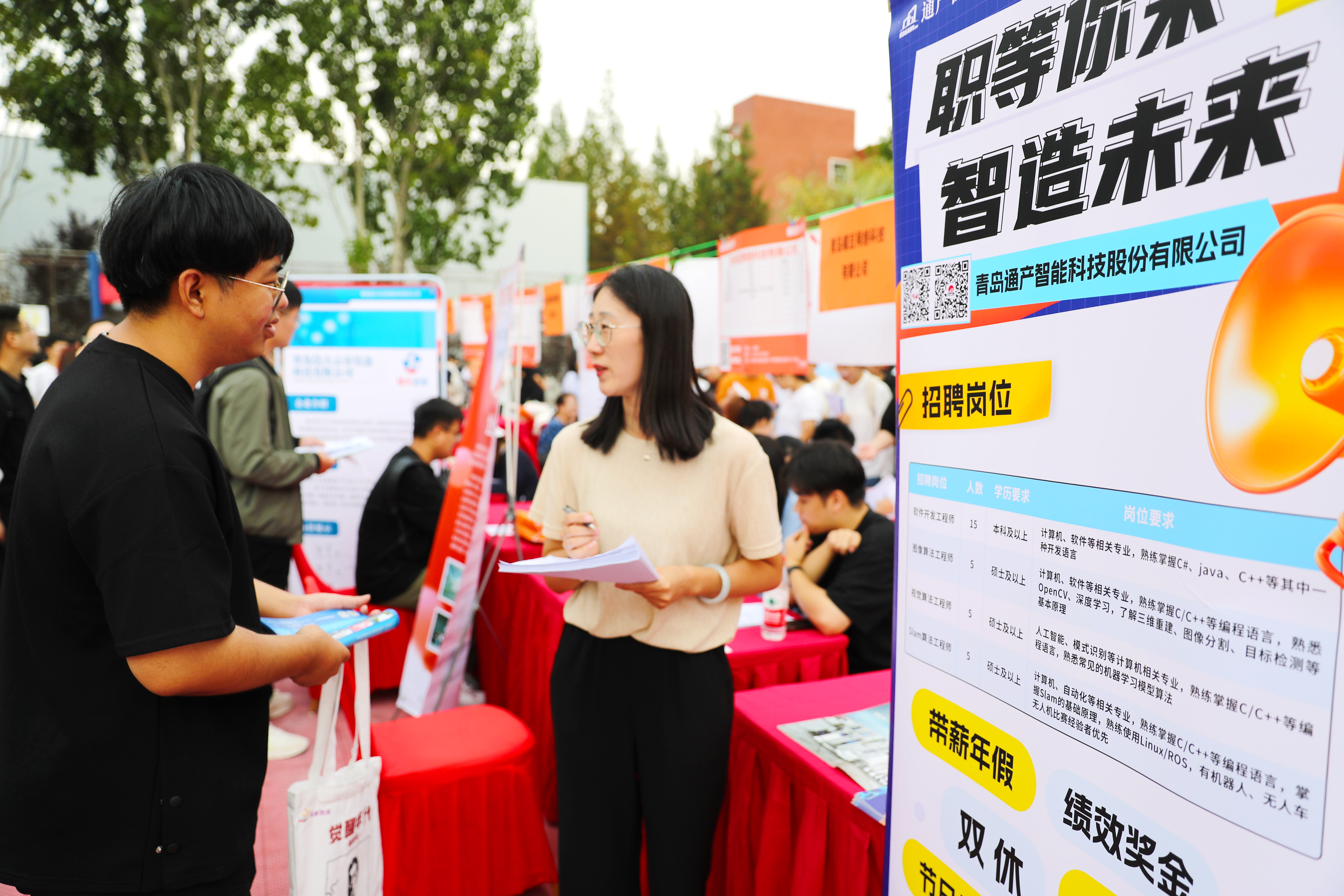 9月23日,大学生在招聘摊位前了解岗位信息.