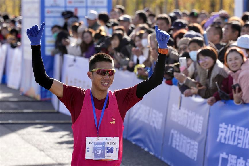 选手冲线后向观众挥手致意.崔文娟摄