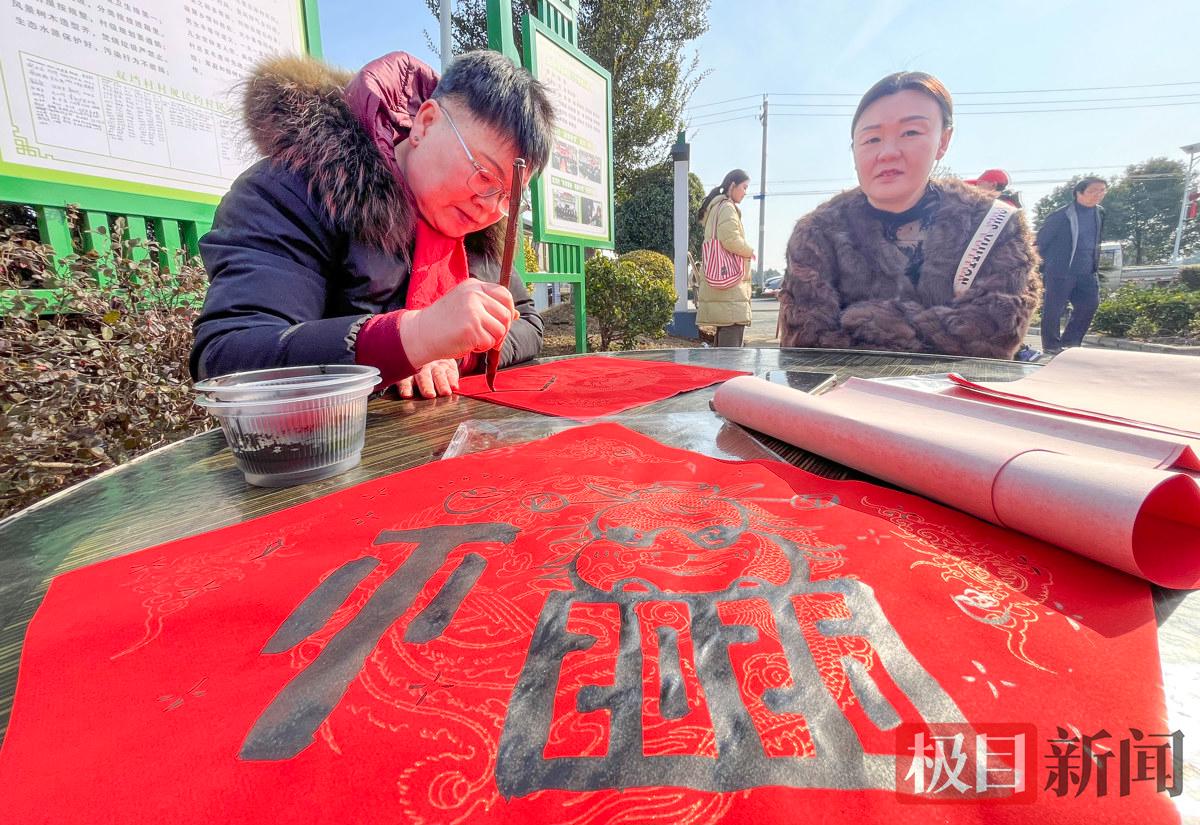 2月8日，荆州区马山镇双垱村团年宴现场，荆州当地书法爱好者容时在为村民写“福”字。（极目新闻记者 黄志刚 摄）.jpg
