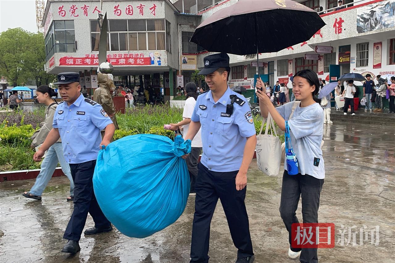 考生自发为雨中搬运行李的民警撑伞.jpg