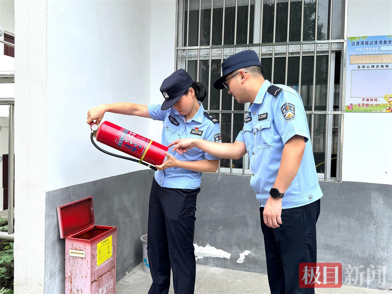 图5：民警在检查校园消防设备.jpg