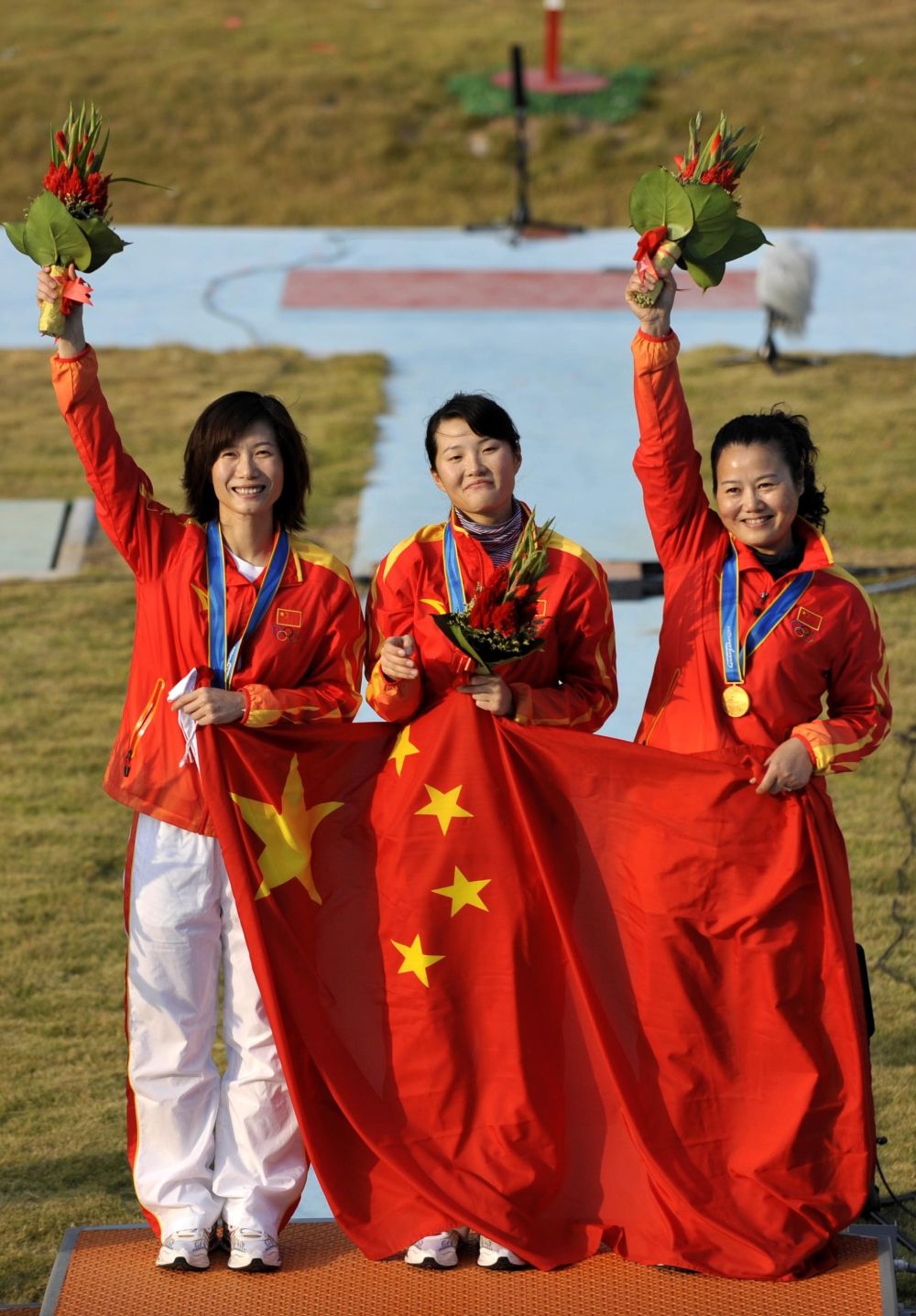 張山(從左至右)獲得2010年廣州亞運會女子雙向飛碟團體冠軍後在領獎臺