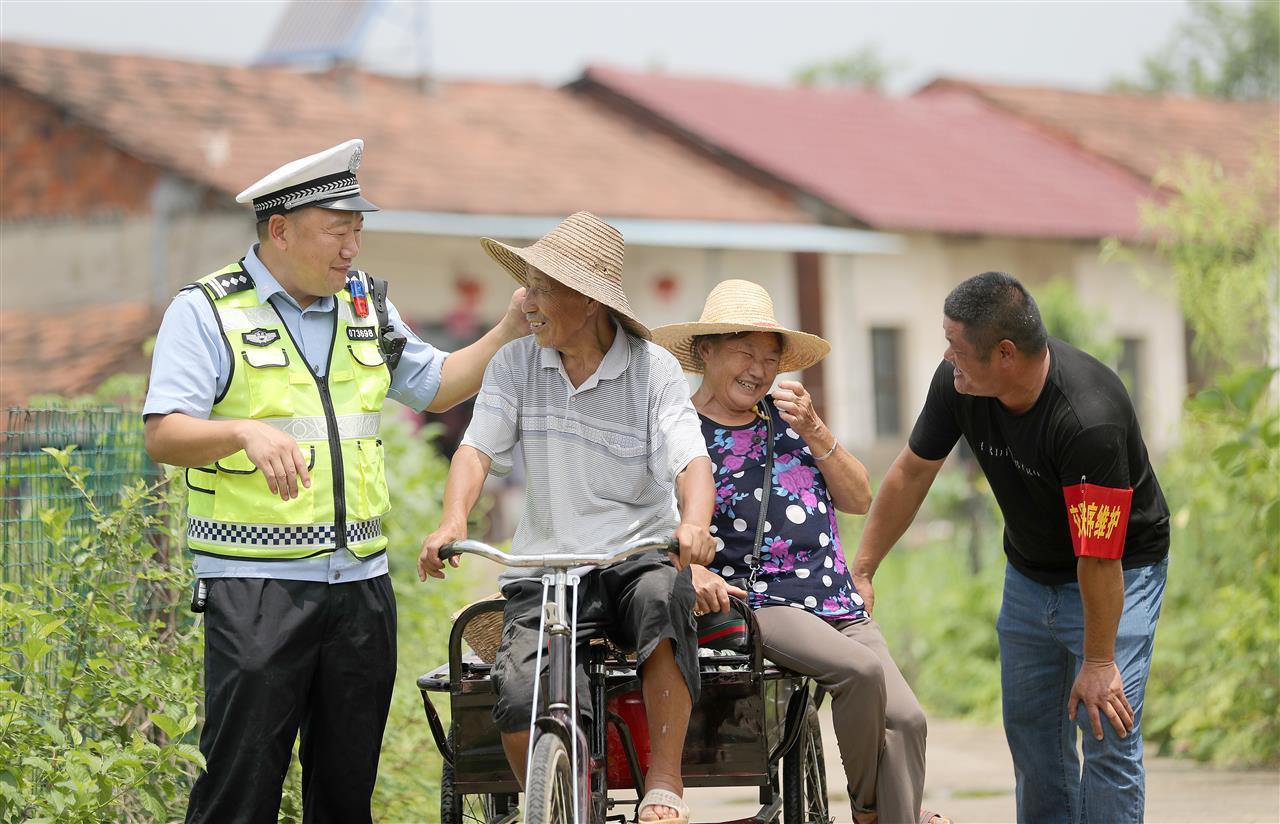 民警联合志愿者在村口开展交通劝导工作.jpg
