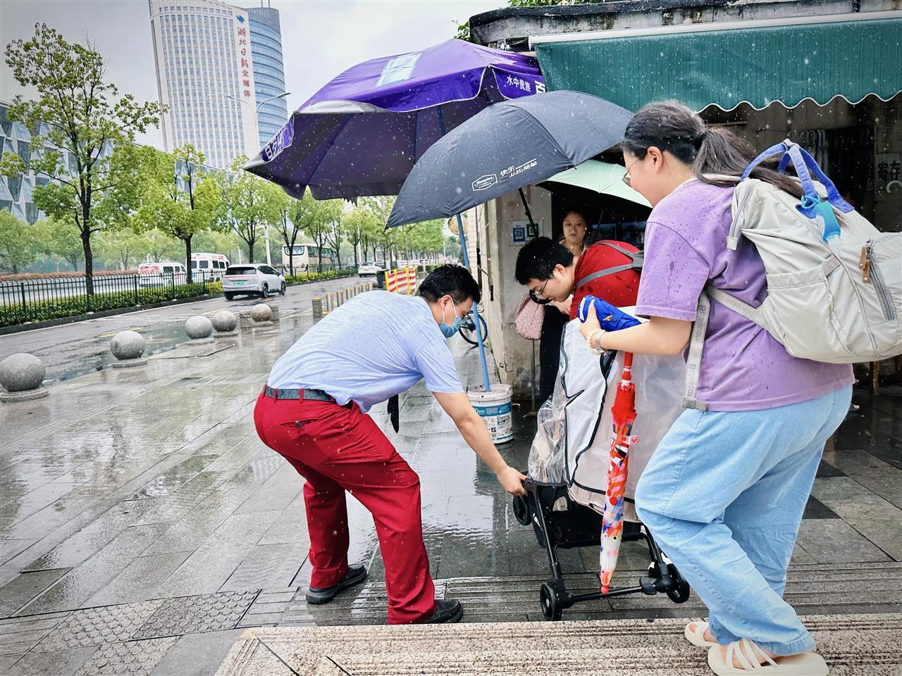 地铁8号线省博湖北日报工作人员在雨天为乘客提供帮助 王娟摄.jpg