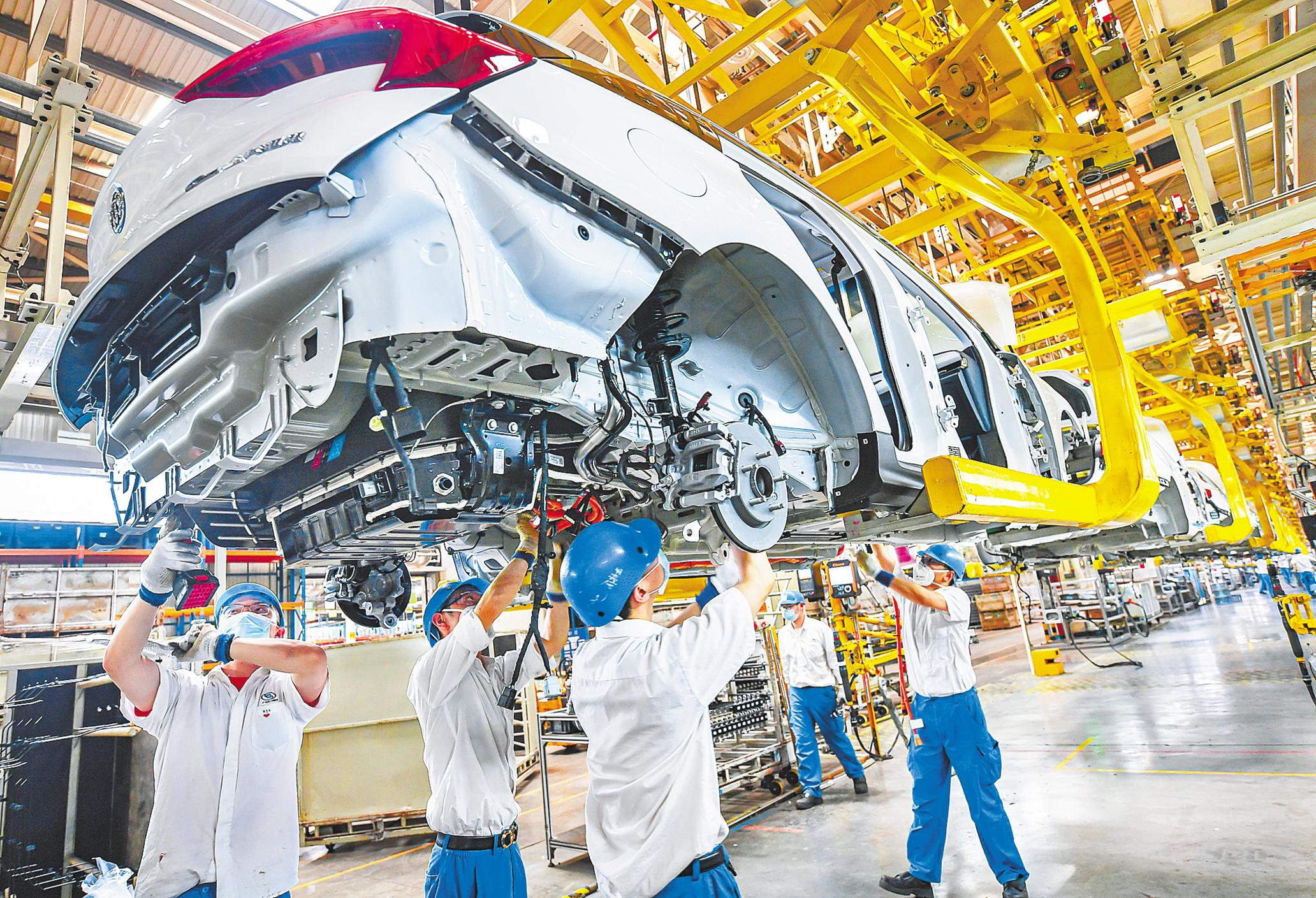 5月18日,上汽通用武汉分公司繁忙的新能源汽车生产线上,工人们正在给