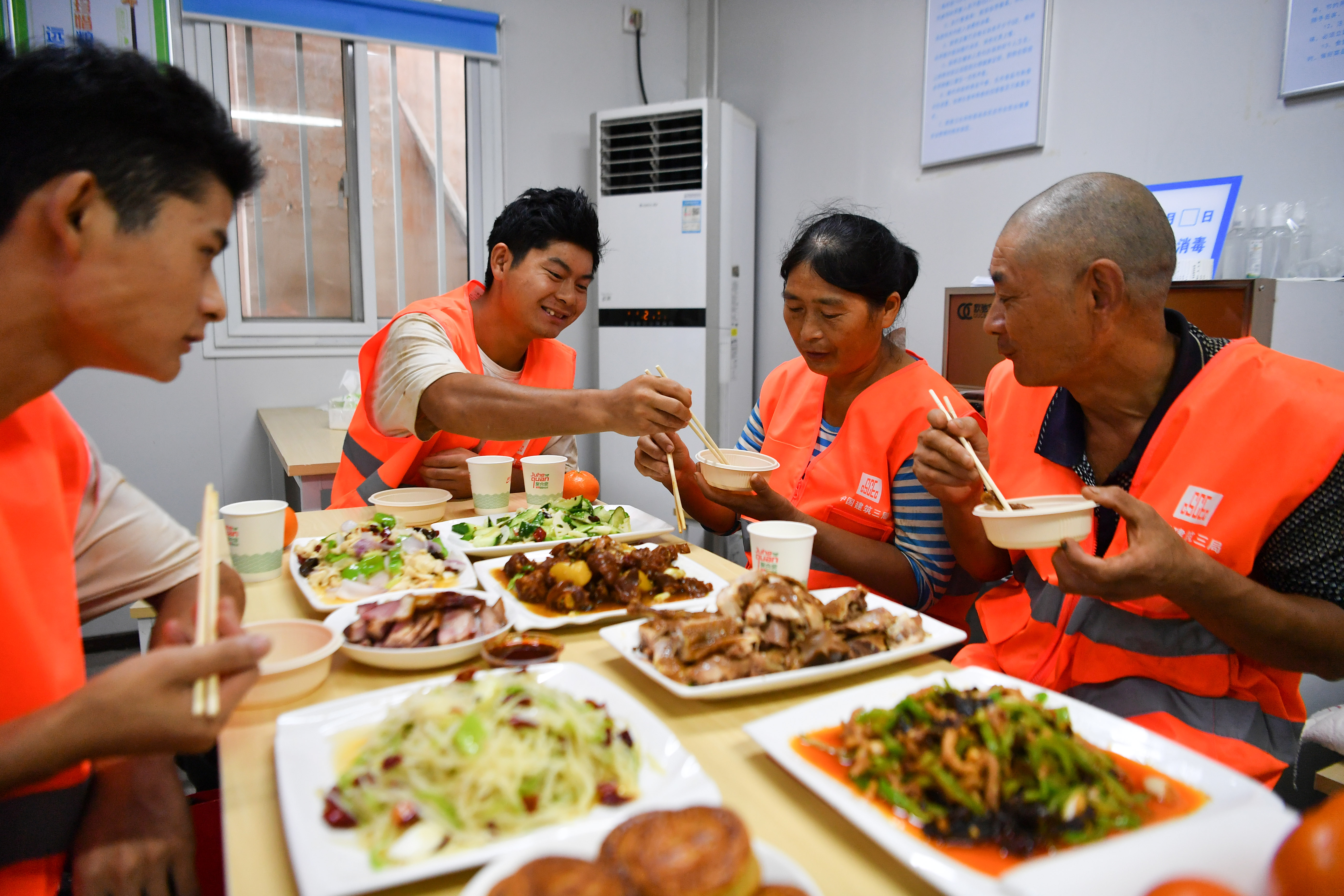 9月9日,农民工张志军一家在工地食堂品尝建设方为他们准备的团圆饭