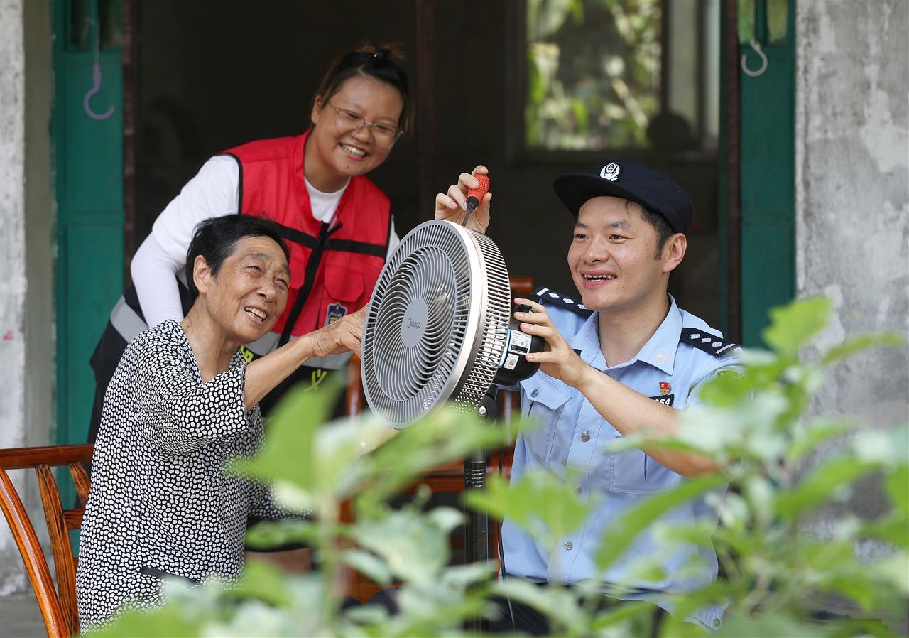 十里铺派出所民警帮助独居老人安装电风扇。.jpg