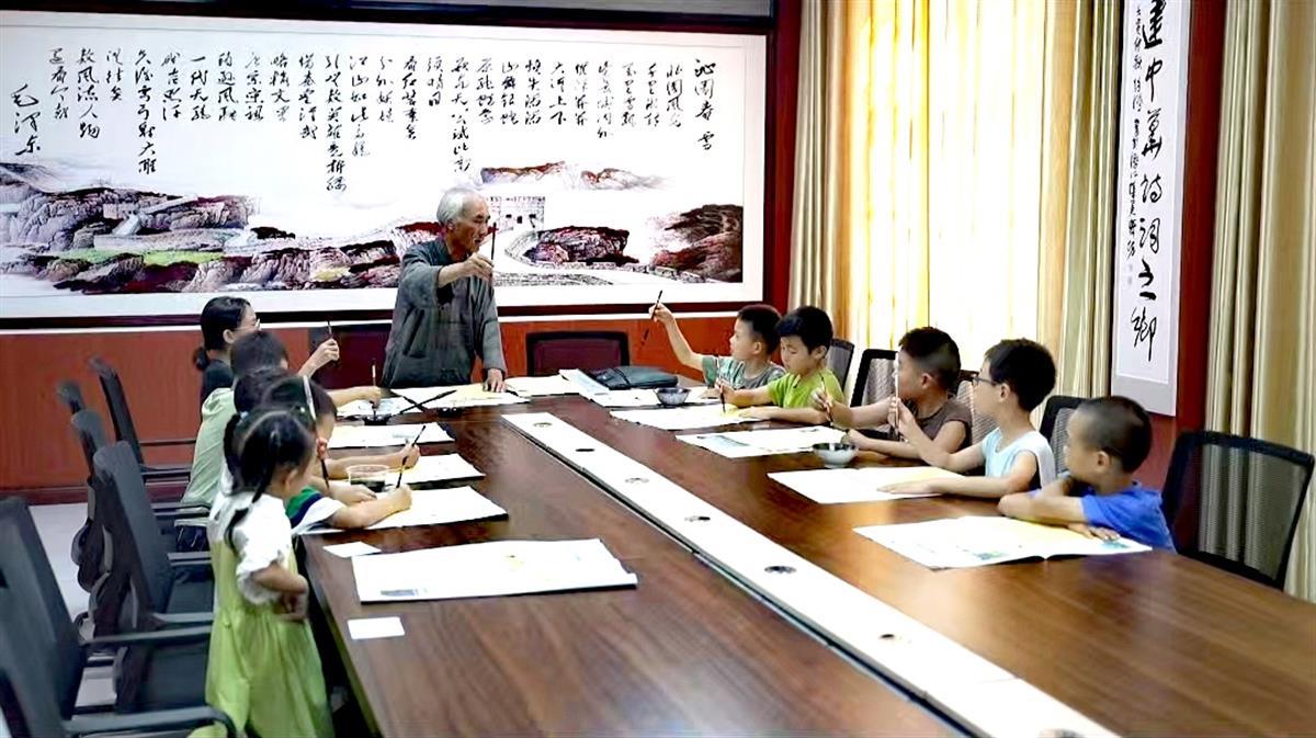 积玉口镇“五老”在学生暑期关爱班辅导学生书法.jpg