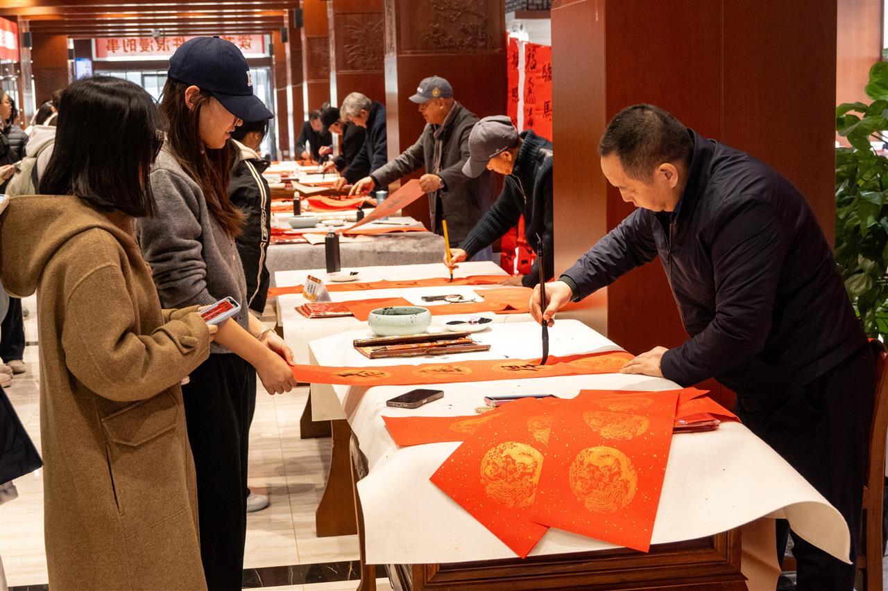 鹰台书画院老师为同学们写春联。马鑫雨 摄.jpg 鹰台书画院老师为同学们写春联。马鑫雨 摄.jpg